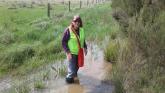 Christine standing in the water flowing over the track to sampling site